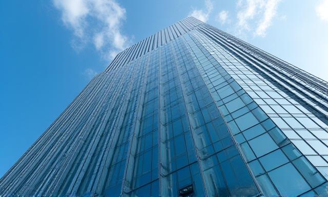 Modern glass office building reflecting the sky